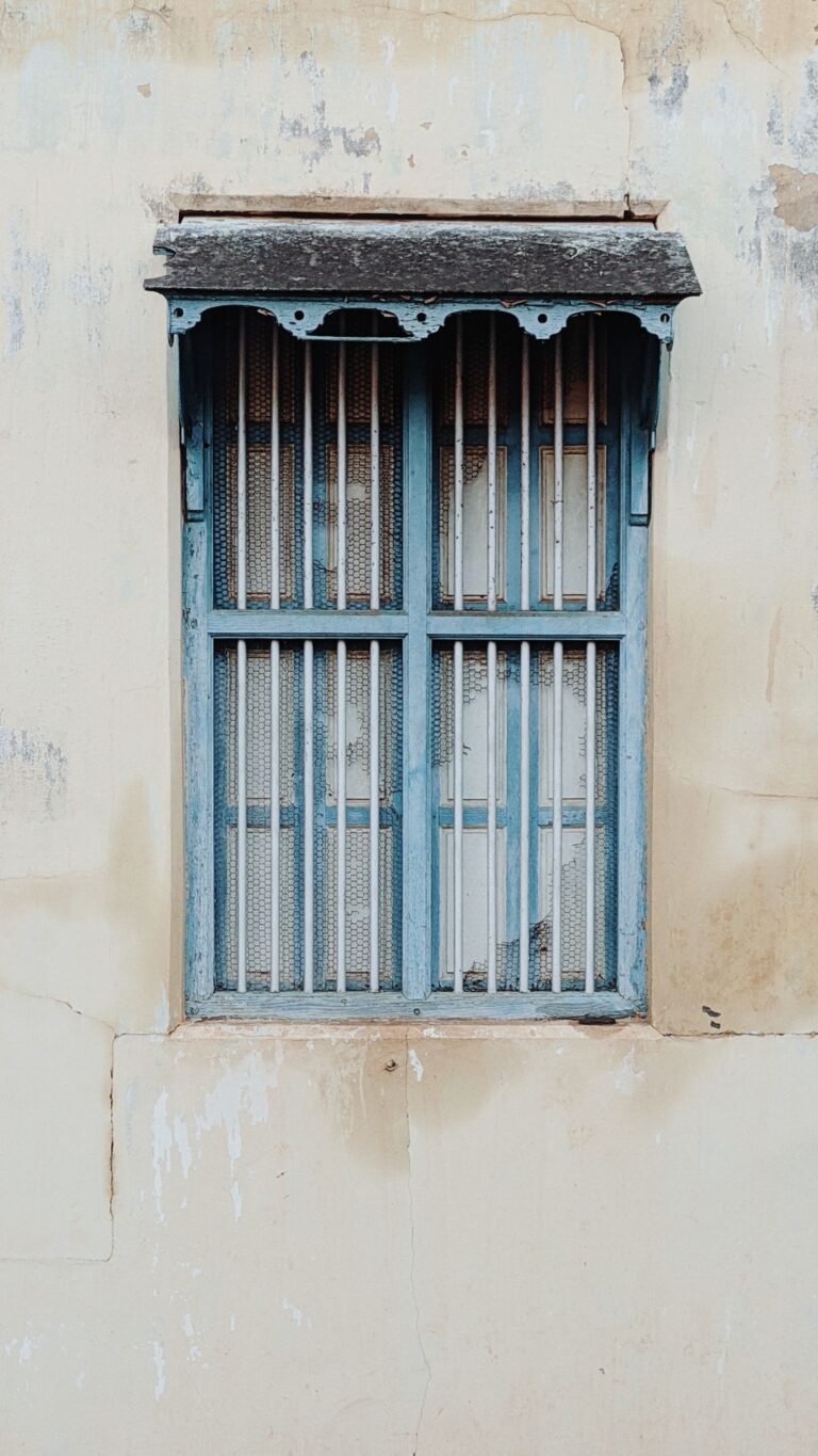 Window frame with metal grill set in a plain wall